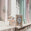 Lattafa Rouat Al Musk perfume bottle and box on pastel colored staircase going up