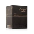 Lattafa Tamima 100ml Eau de Parfum — A black perfume bottle with a wooden cap and a rose gold label sits next to its matching black textured box with rose gold Arabic calligraphy and text. | Lattafa Tamima 100ml Eau de Parfum — Botol minyak wangi hitam dengan penutup kayu dan label emas mawar duduk bersebelahan dengan